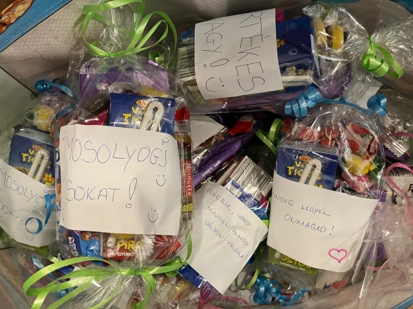 Ajándékcsomagok egy dobozban, a feliratokon: Mosolyogj sokat! és Értékes vagy!